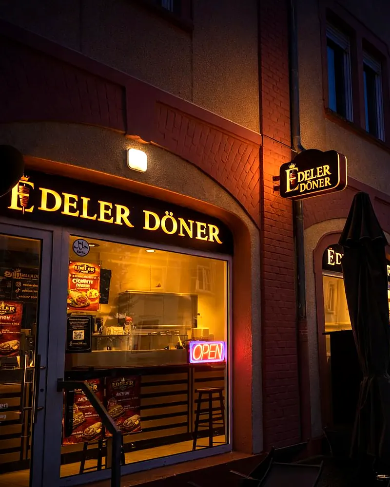 Der Edeler-Döner-Laden am Abend mit beleuchtetem Schild